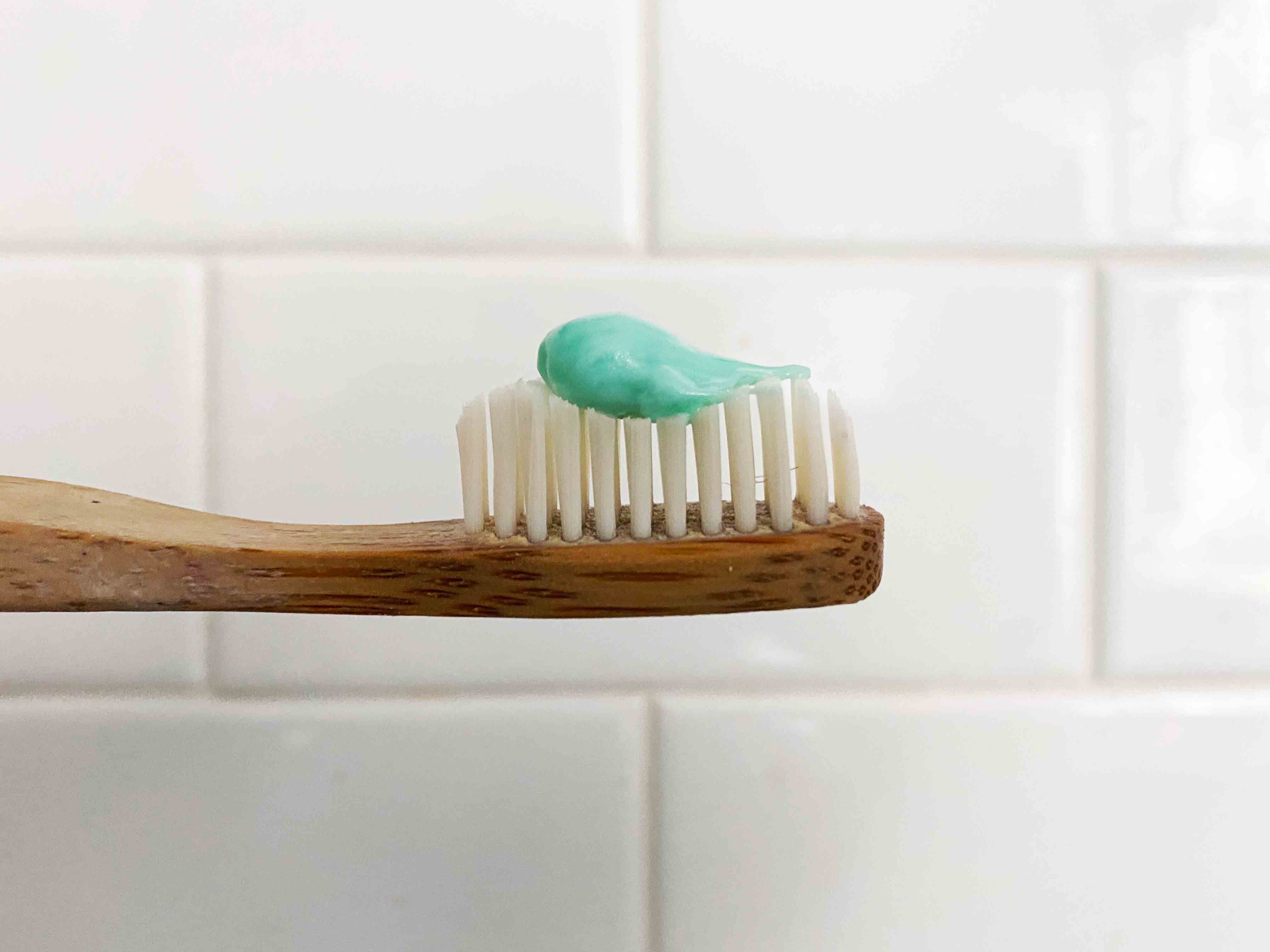 profile of bamboo toothbrush with green toothpaste