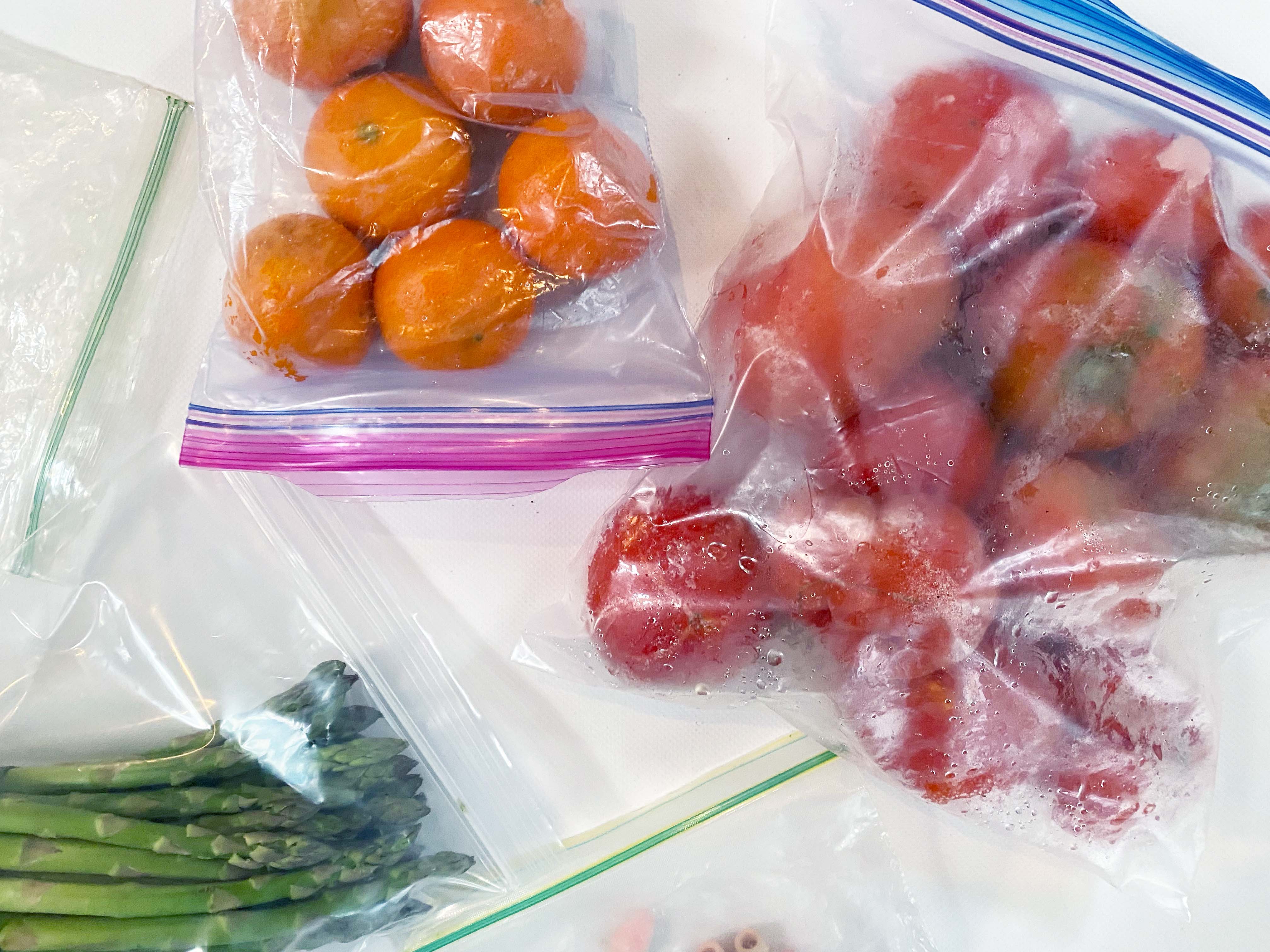 tomatoes, clementines and asparagus in ziploc bags